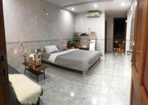 a bedroom with a large bed and a table at DU Home Huế in Thôn An Hòa