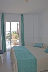 a bedroom with two beds and a view of the ocean at Hostal Brisa Marina in Port d'Alcudia