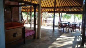 a porch of a house with a table and chairs at Teluk Indah Beach & Pool Villa in Tejakula