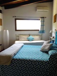 a bedroom with two beds and a window at B&B La Tasgia in Aggius