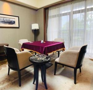une salle à manger avec une table et des chaises violettes dans l'établissement Country Garden Phoenix Hotel Yiyang, à Heshanqu