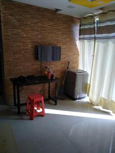 ein Wohnzimmer mit einem Tisch und einem roten Hocker in der Unterkunft Richmax pg in Jāmb