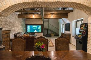 a living room with a television and a table and chairs at Luxus Wellness Apartman in Békéscsaba