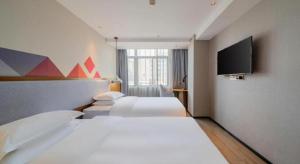 a hotel room with two beds and a flat screen tv at Borrman Hotel Zhanjiang Wuchuan Jinsha Plaza in Xindi +249 photos