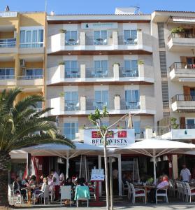 a hotel with people sitting at tables in front of it at Hostal Brisa Marina in Port d'Alcudia