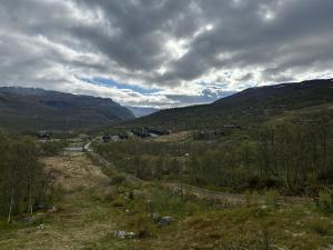 a view of a valley with mountains and a road at Lekker tømmerhytte in Tyinkrysset +3 photos