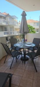 a table and chairs on a balcony with an umbrella at Paralio Place in Paralio Astros