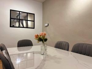 a table with chairs and a vase of flowers on it at Modern Casual Style Haus 4Room`````Alma in Bukit Mertajam