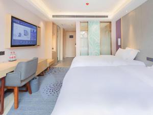 a hotel room with two beds and a desk and a tv at GreenTree Eastern Hotel Kashgar Oid City Xiangfei Park in Kashgar +179 photos