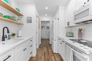 a kitchen with white cabinets and a sink at Gorgeous Beach Condo with Private Patio #134 in Carpinteria