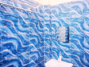 bagno con piastrelle blu e servizi igienici. di "Om Sadan" Guest House Ayodhya Dhaam a Ayodhya