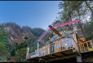 a house on the side of a mountain at UrWish TreeHouse cottageJacuzzi in Jibhi