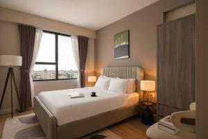 Una habitación de hotel con una cama y una ventana grande. en Downtown Saigon, District 1, 3 Bedroom + 2 WC Modern Condo Near Bui Vien, en Ho Chi Minh