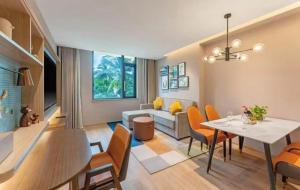 una sala de estar con una mesa y un sofá en Home2 Suites by Hilton Xishuangbanna, en Jinghong