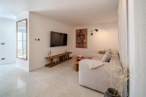 a white living room with a couch and a tv at Villa Kaleta Brac in Sutivan
