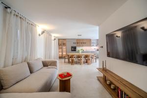 a living room with a couch and a large television at Villa Kaleta Brac in Sutivan