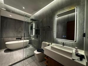 une salle de bain avec un lavabo, des toilettes et un miroir dans l'établissement The Nature Villa Phuket, à Rawai Beach