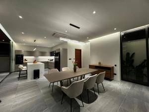 une salle à manger et une cuisine avec une table et des chaises dans l'établissement The Nature Villa Phuket, à Rawai Beach