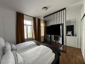 a bedroom with a large bed and a flat screen tv at Historical Luxury Homes - Familiensuite mit Terrasse in Freiburg im Breisgau
