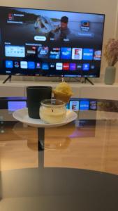 a plate of food on a table in front of a tv at Cozy two rooms appartment in Stockholm +4 photos