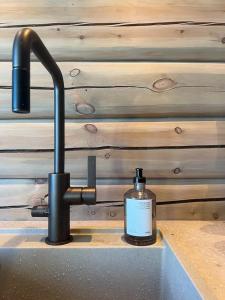 a bottle of soap sitting on a counter next to a sink at Timber Cabin By The Ski Slopes In Oppdal in Oppdal
