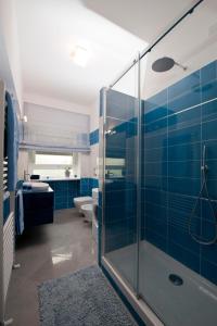 y baño con azulejos azules y ducha de cristal. en Residenza San Pio V, en Roma