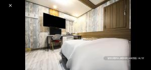 ソウルにあるRamon Hotelのベッドと薄型テレビのある寝室 +2枚の写真