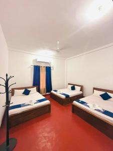 亭可马里Trinco Star Hotel的红色楼层的客房内的两张床 更多18张照片