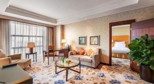 a hotel room with a bed and a living room at Kunshan Newport Hotel in Kunshan +88 photos