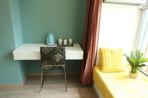 - un bureau dans une chambre avec une chaise à côté d'une fenêtre dans l'établissement IF Hotel, à Chongqing