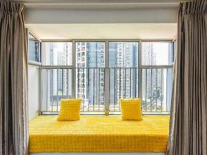 une grande fenêtre avec deux oreillers jaunes dans une pièce dans l'établissement IF Hotel, à Chongqing