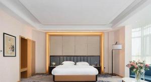 Uma cama ou camas num quarto em Metropolo Hotel Yining Development Zone Hanma Building