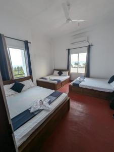 亭可马里Trinco Star Hotel的有两张床的房间有两扇窗户