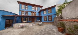 a blue house with chairs and tables in a courtyard at Lal Hotel Bursa in Bursa
