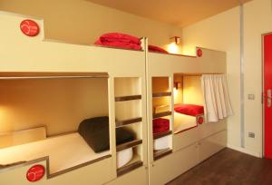 two bunk beds in a small room with red accents at PILOT Design Hostel & Bar in Porto