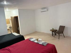a bedroom with a red bed and a chair and a chair at Casa Constanza in Valladolid