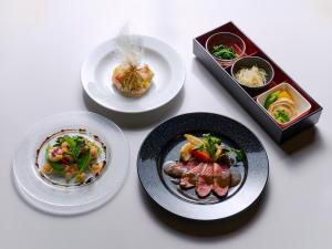 a table with plates of food and a box of food at Ishinoyu Lodge in Yamanouchi