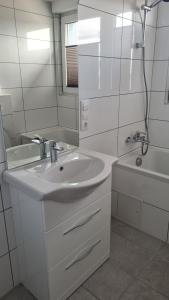 een witte badkamer met een wastafel en een douche bij Apartment Hermeskeil 3 in Hermeskeil