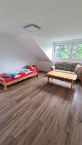 een woonkamer met twee bedden en een bank bij Apartment Hermeskeil 3 in Hermeskeil