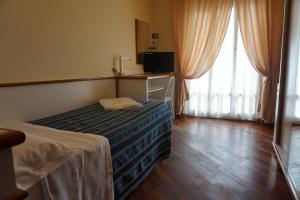 a hotel room with a bed and a window at Hotel Tritone in Porto San Giorgio