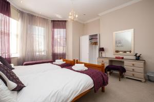 Un dormitorio con una cama, un escritorio y un espejo. en The Cavendish, en Eastbourne