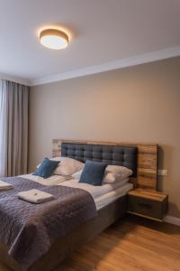 ein Schlafzimmer mit einem großen Bett mit blauen Kissen in der Unterkunft Papillon Apartamenty Letnica Gdańsk in Danzig