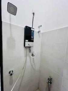 a bathroom with a shower with a tv on the wall at AM Homestay Kijal in Kemaman