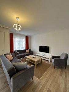 un salon avec deux canapés et une télévision dans l'établissement Şehir Merkezinde Kiralık Daire, à Fethiye