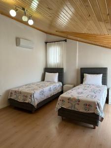 - 2 lits dans une chambre dotée de parquet dans l'établissement Şehir Merkezinde Kiralık Daire, à Fethiye