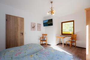 a bedroom with a bed and a table and chairs at Ferienwohnung Mankei in Schönau am Königssee