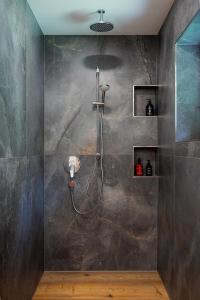 a shower in a bathroom with a stone wall at Ferienwohnung Mankei in Schönau am Königssee +61 photos