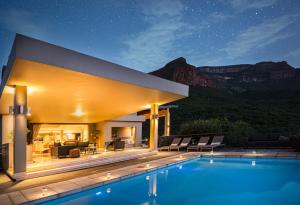 una villa con piscina di notte di umVangati House a Hoedspruit