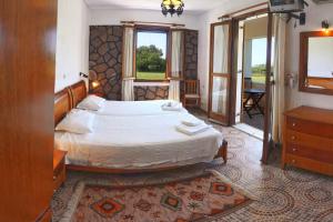 a bedroom with a large bed and a window at Lela Kaptani Eftalou Olive Grove in Mithymna