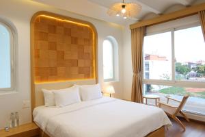 a bedroom with a large white bed and a window at Lovela Villa Phan Thiết in Ấp Bình Hưng +49 photos